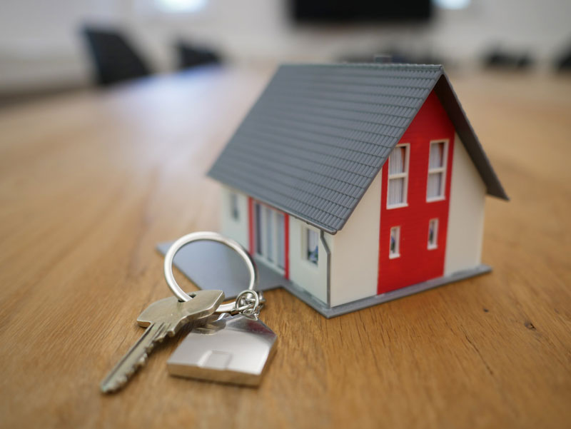 A toy house next to a set of keys.
