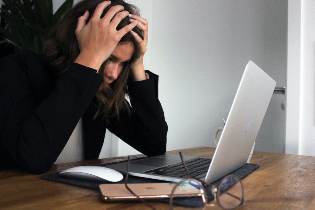 A woman is stressed out in front of her computer.