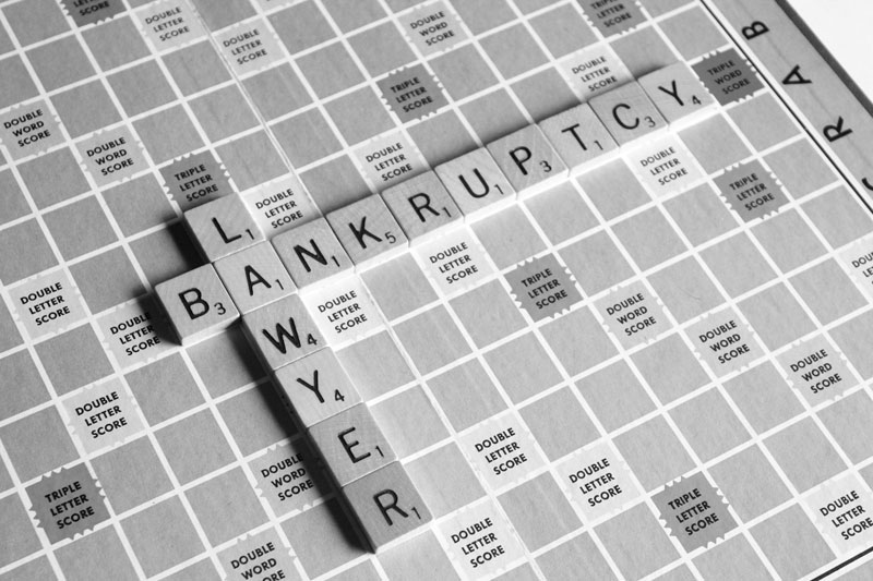 The words bankruptcy lawyer written with wooden cubes on a board.